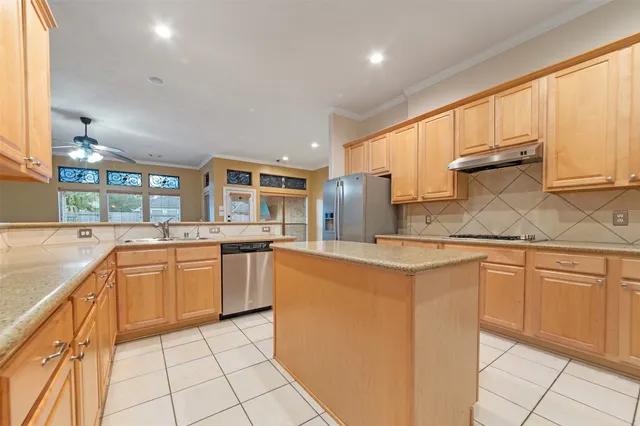 a kitchen with stainless steel appliances granite countertop a stove a sink and a refrigerator