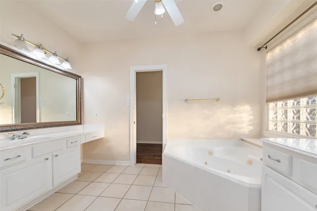 a bathroom with a bathtub a mirror a vanity and a shower