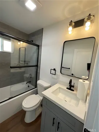 a bathroom with a toilet sink a mirror and shower
