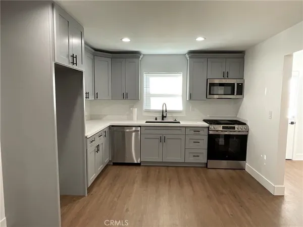 a kitchen with granite countertop a refrigerator stove top oven and sink