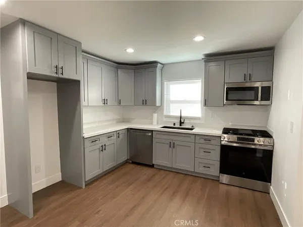 a kitchen with granite countertop a stove top oven sink and cabinets