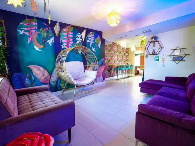 a living room with furniture a rug and a wall painting