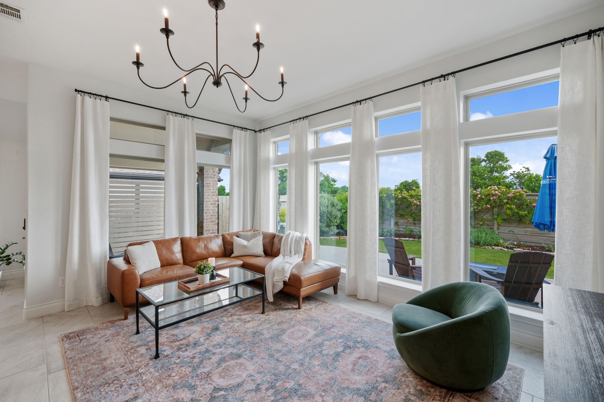 2119 Blackhawk Ridge Lane Manvel, TX 77578 - Photo 6 of 49 Bright and inviting living room bathed in natural light from a wall of oversized windows overlooking the private backyard. Features accent wall, elegant chandelier, and direct access to the covered patio.
