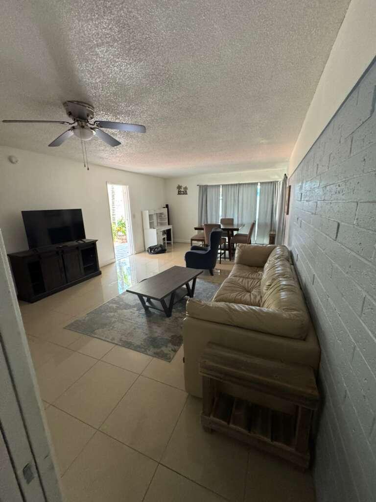 1001 South Riverside Drive, Unit 104 Pompano Beach, FL 33062 - Photo 6 of 6 a living room with furniture and a flat screen tv