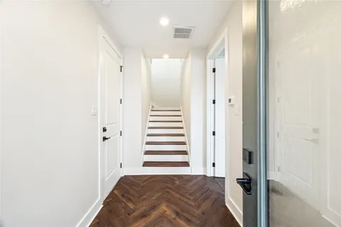 a view of a hallway with a bedroom and wooden floor