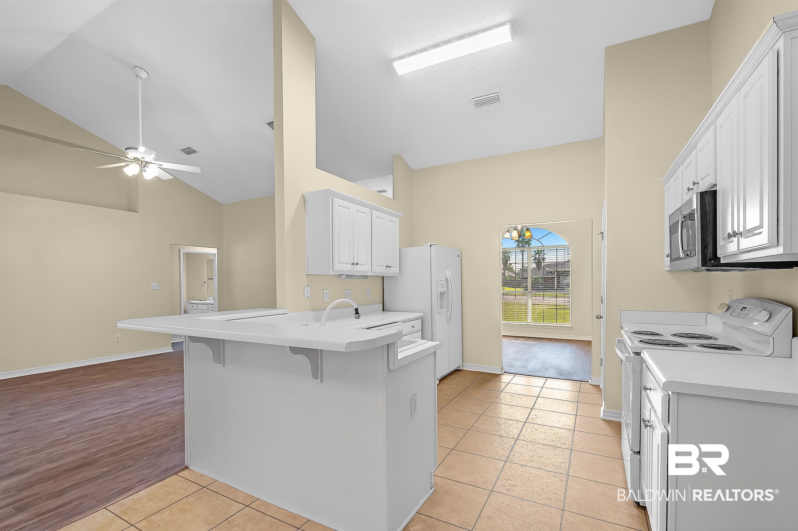 12443 Venice Boulevard Foley, AL 36535 - Photo 32 of 59 Kitchen with a breakfast bar area, white appliances, light hardwood / wood-style floors, kitchen peninsula, and ceiling fan