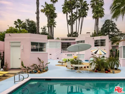 a view of a patio with table and chairs potted plants and palm tree