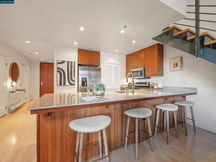 a kitchen with stainless steel appliances granite countertop a sink and a refrigerator