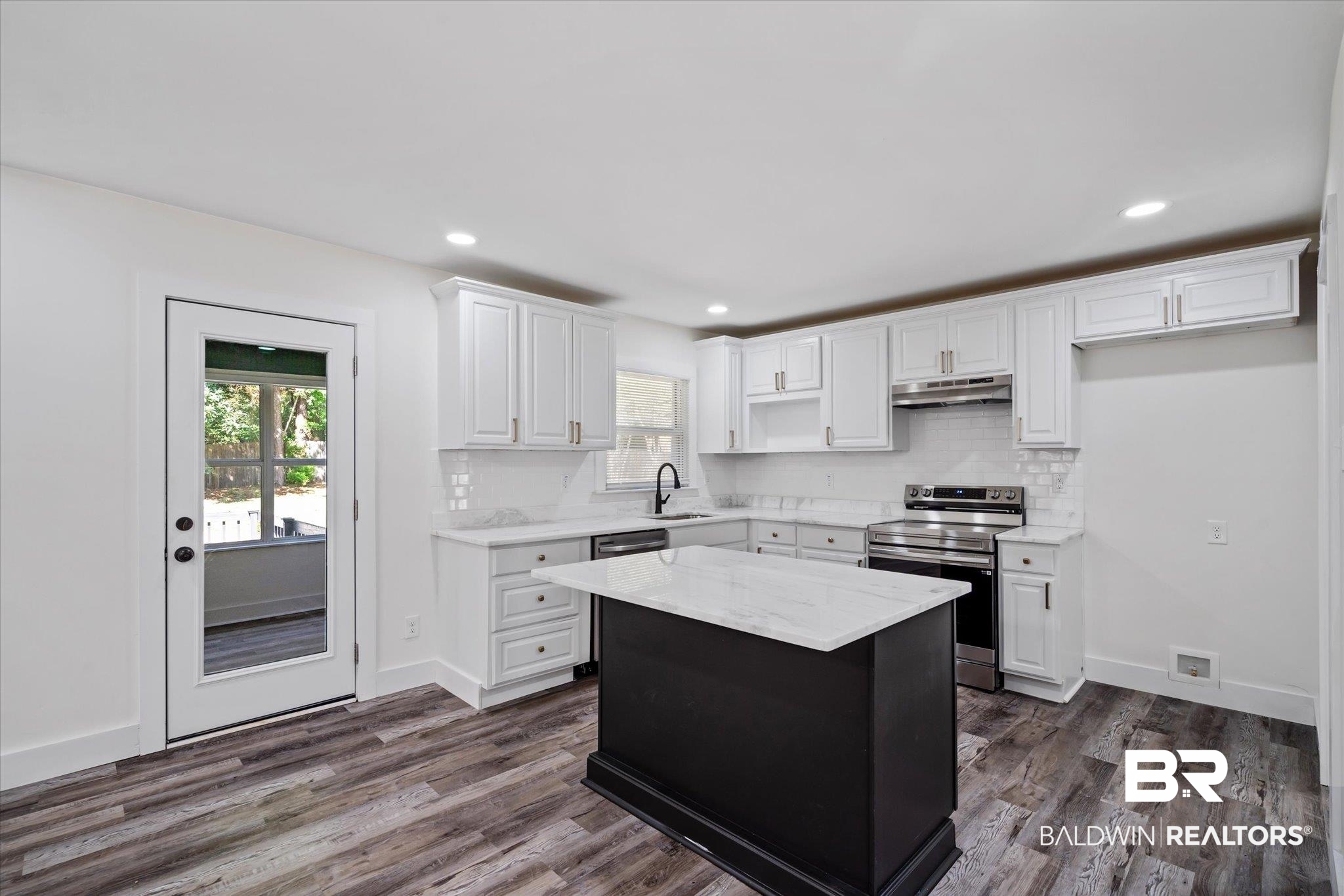 308 Byron Avenue West Mobile, AL 36609 - Photo 6 of 33 Kitchen with appliances with stainless steel finishes, dark hardwood / wood-style flooring, a kitchen island, and white cabinets