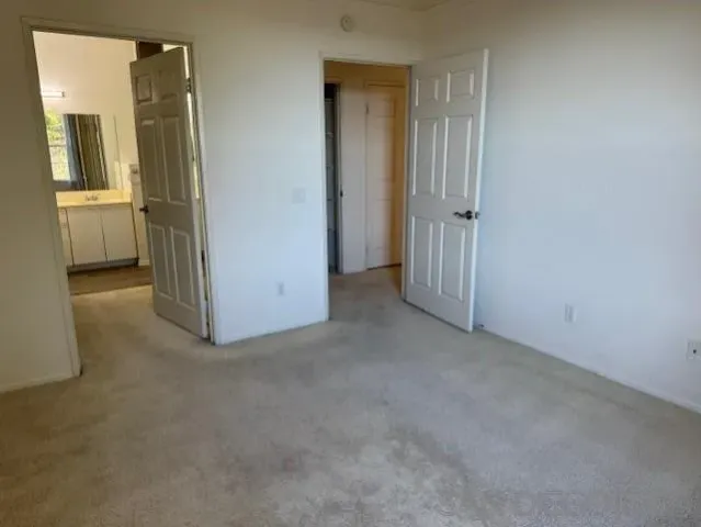 an empty room with windows and fireplace