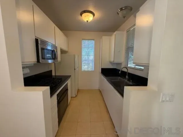 a kitchen with granite countertop a sink and a stove top oven