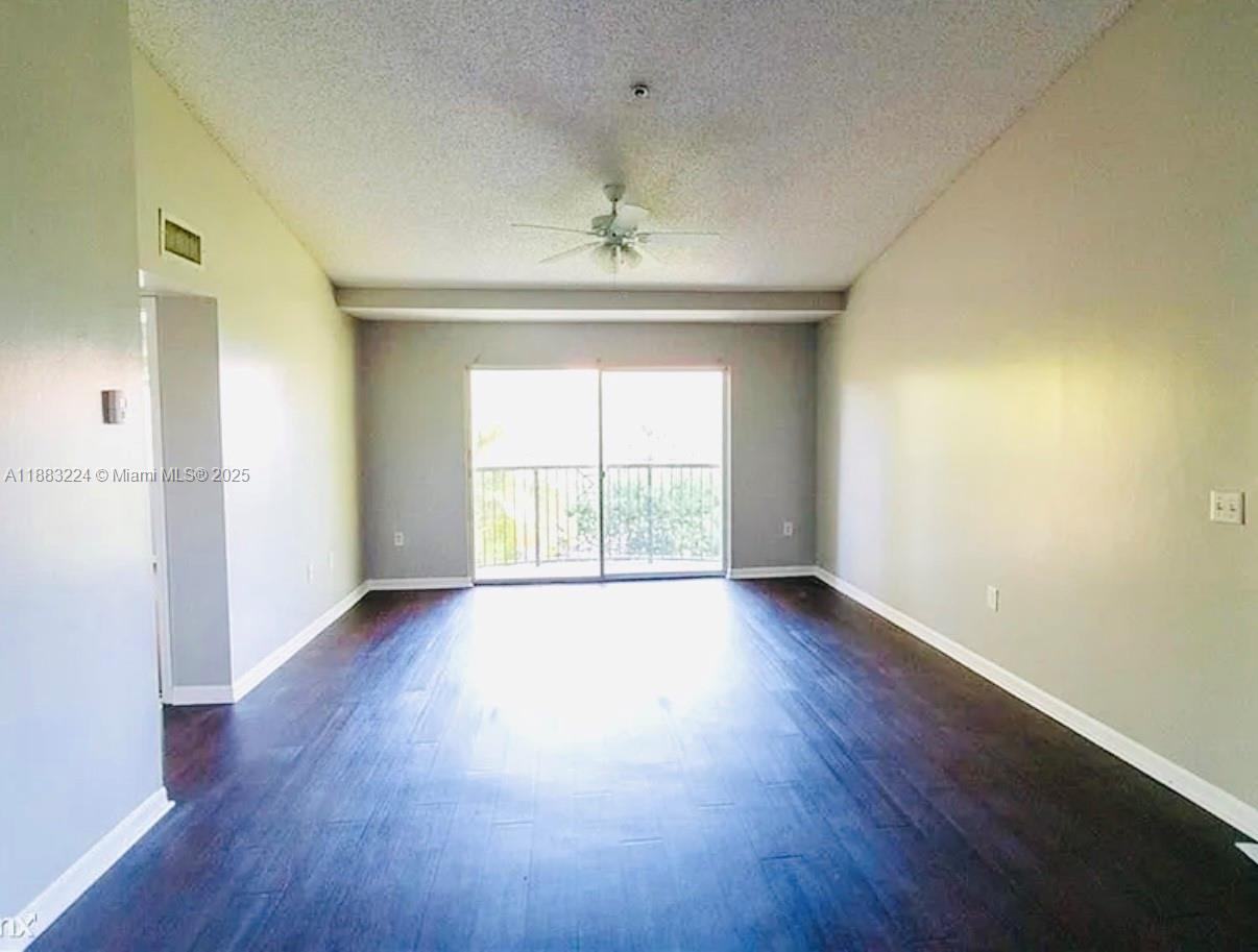4183 Haverhill Road, Unit 703 West Palm Beach, FL 33417 - Photo 5 of 14 wooden floor in an empty room with a window