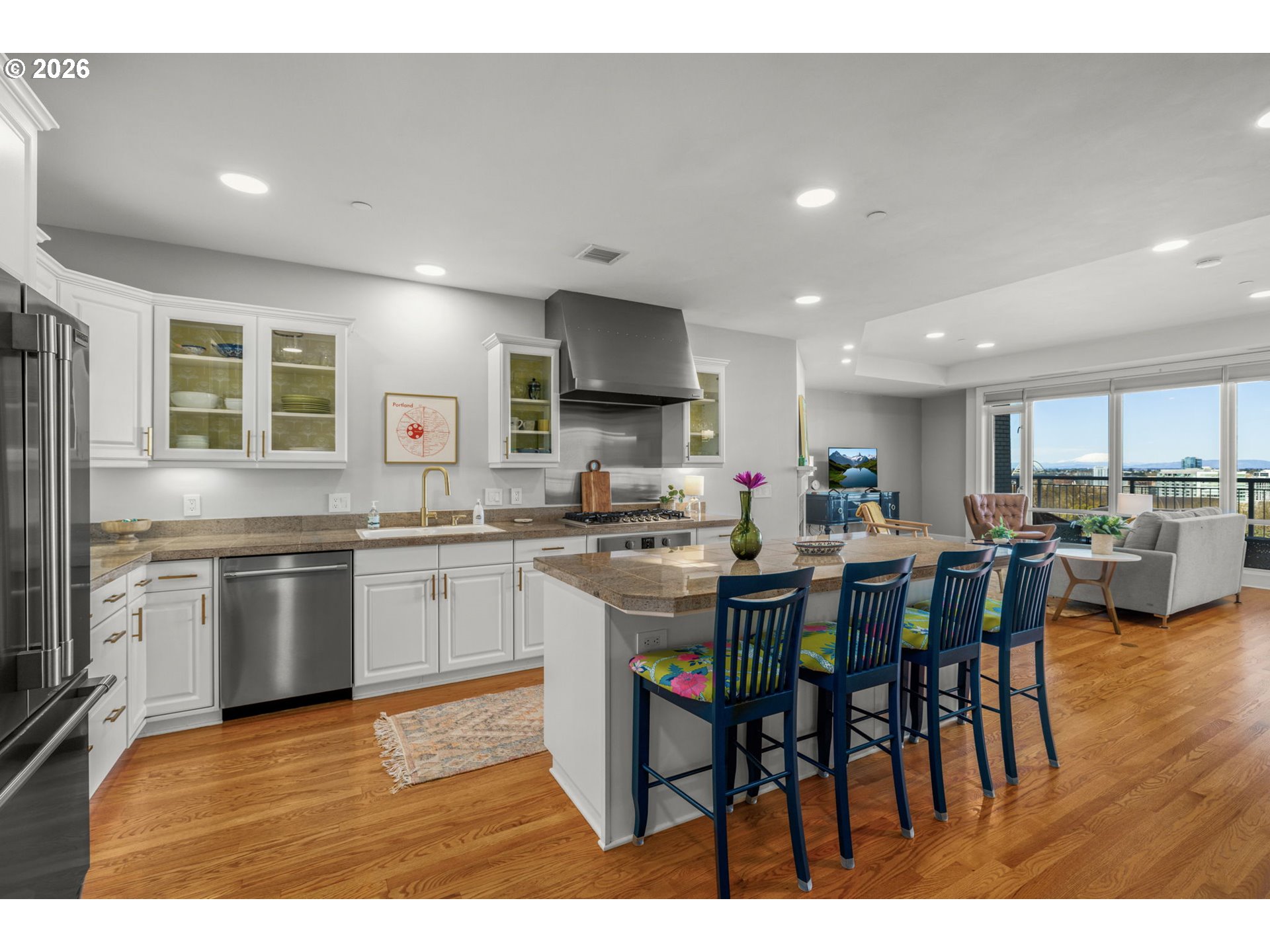 2020 Southwest Market St Drive, Unit 303 Portland, OR 97201 - Photo 12 of 31 a kitchen with stainless steel appliances kitchen island granite countertop a table chairs sink and cabinets
