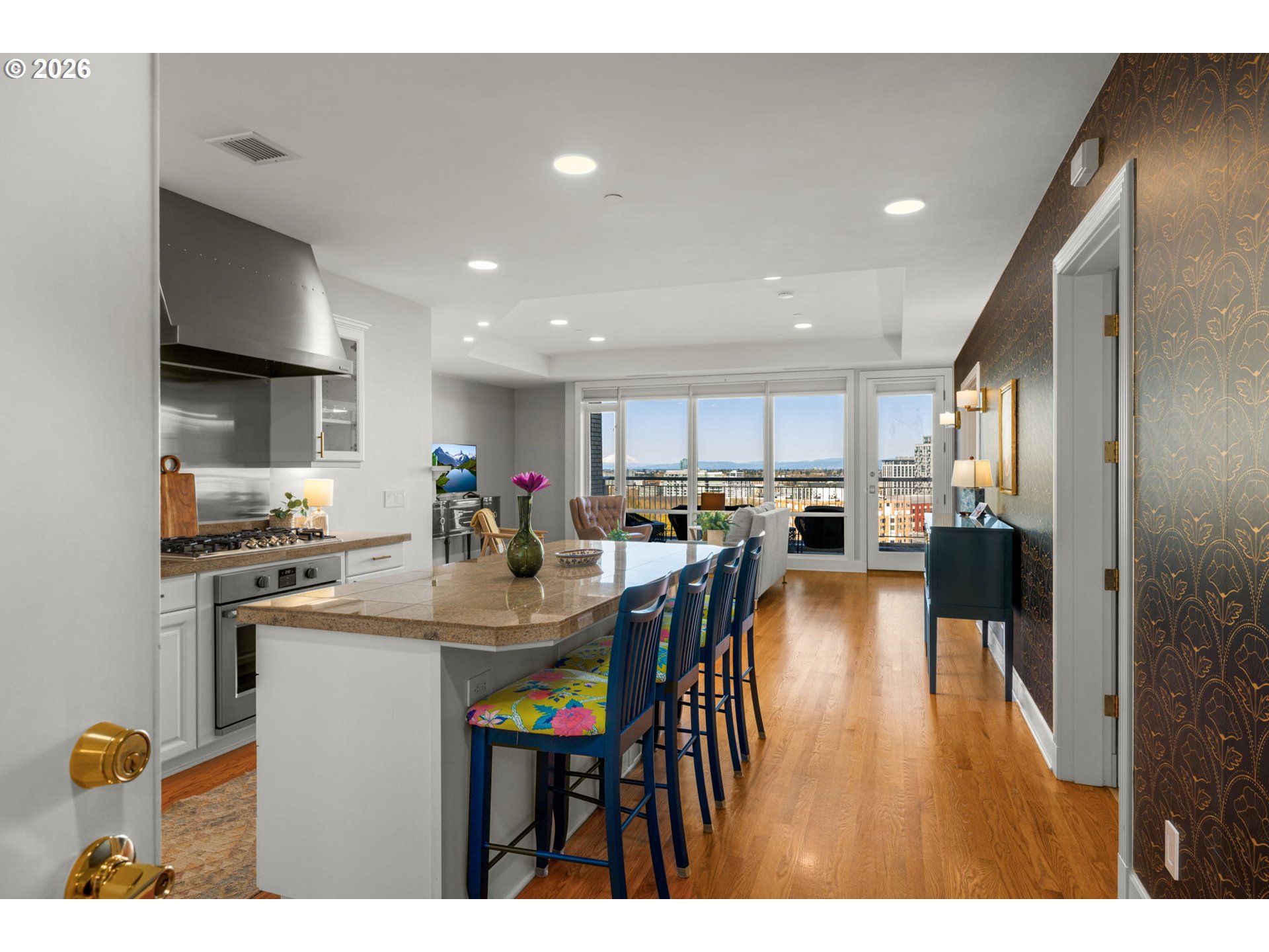 2020 Southwest Market St Drive, Unit 303 Portland, OR 97201 - Photo 2 of 31 a open kitchen with stainless steel appliances kitchen island granite countertop a refrigerator a stove a sink dishwasher with a dining table and chairs with wooden floor