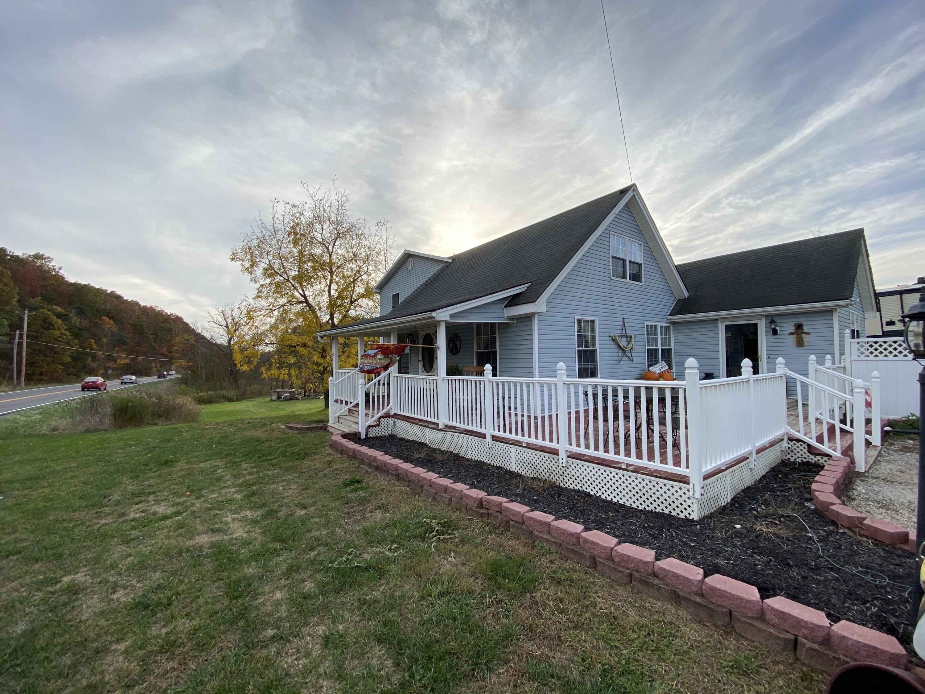 a view of a house with a yard and deck