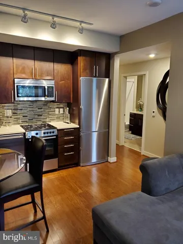 a kitchen with stainless steel appliances granite countertop a refrigerator and a stove top oven