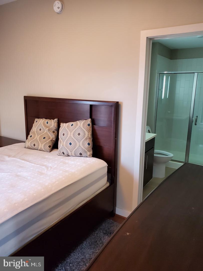 1320 Fenwick Lane, Unit 700 Silver Spring, MD 20910 - Photo 8 of 11 a bedroom with a bed and a mirror