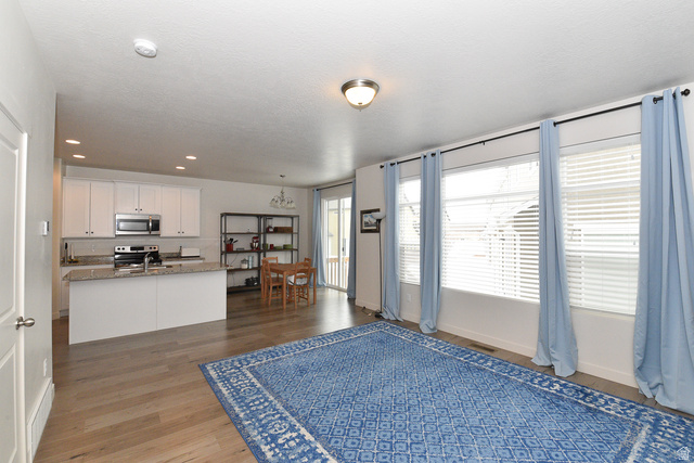 1632 North Apache Road Saratoga Springs, UT 84045 - Photo 3 of 28 Open-concept living area with wood-finish flooring, recessed lighting, and large windows