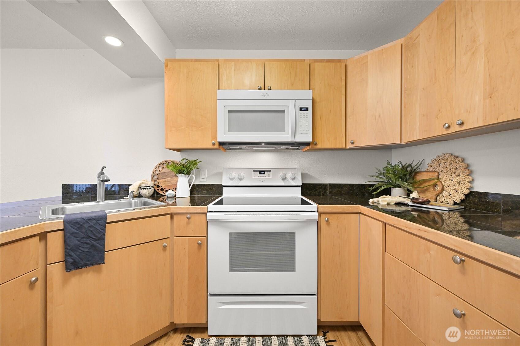 444 South State Street, Unit 317 Bellingham, WA 98225 - Photo 8 of 27 a kitchen with a stove top oven sink and cabinets