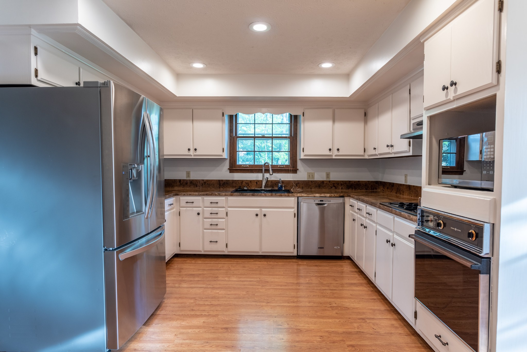 6948 Stone Creek Road Nashville, TN 37221 - Photo 9 of 37 a kitchen with granite countertop a refrigerator stove top oven and sink