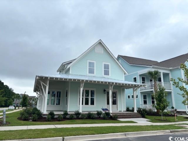 Farmhouse with covered porch and a front yard