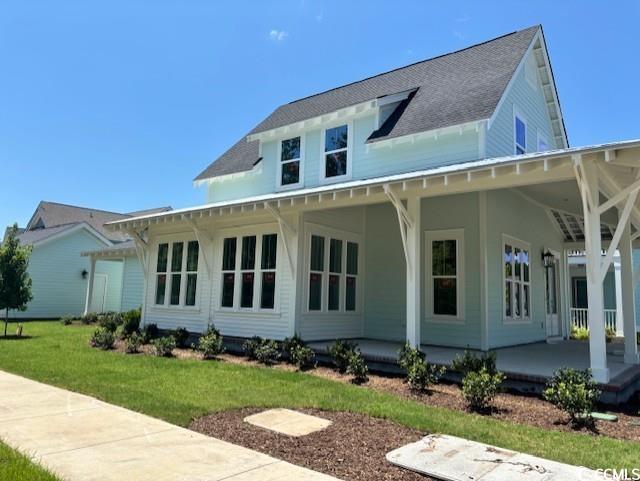 side view of house featuring a wrap porch and sunr