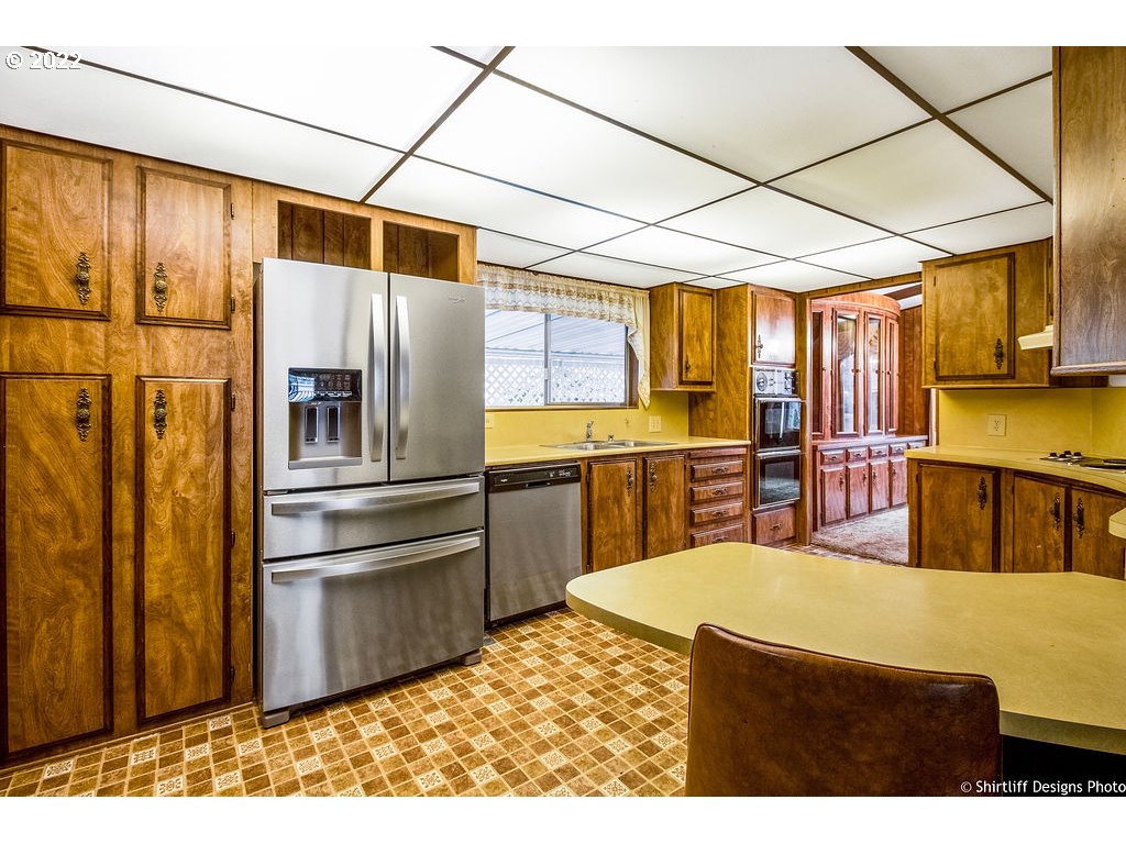 1125 58th Street, Unit 20 Springfield, OR 97478 - Photo 3 of 29 a kitchen with stainless steel appliances granite countertop a refrigerator a sink and blue cabinets
