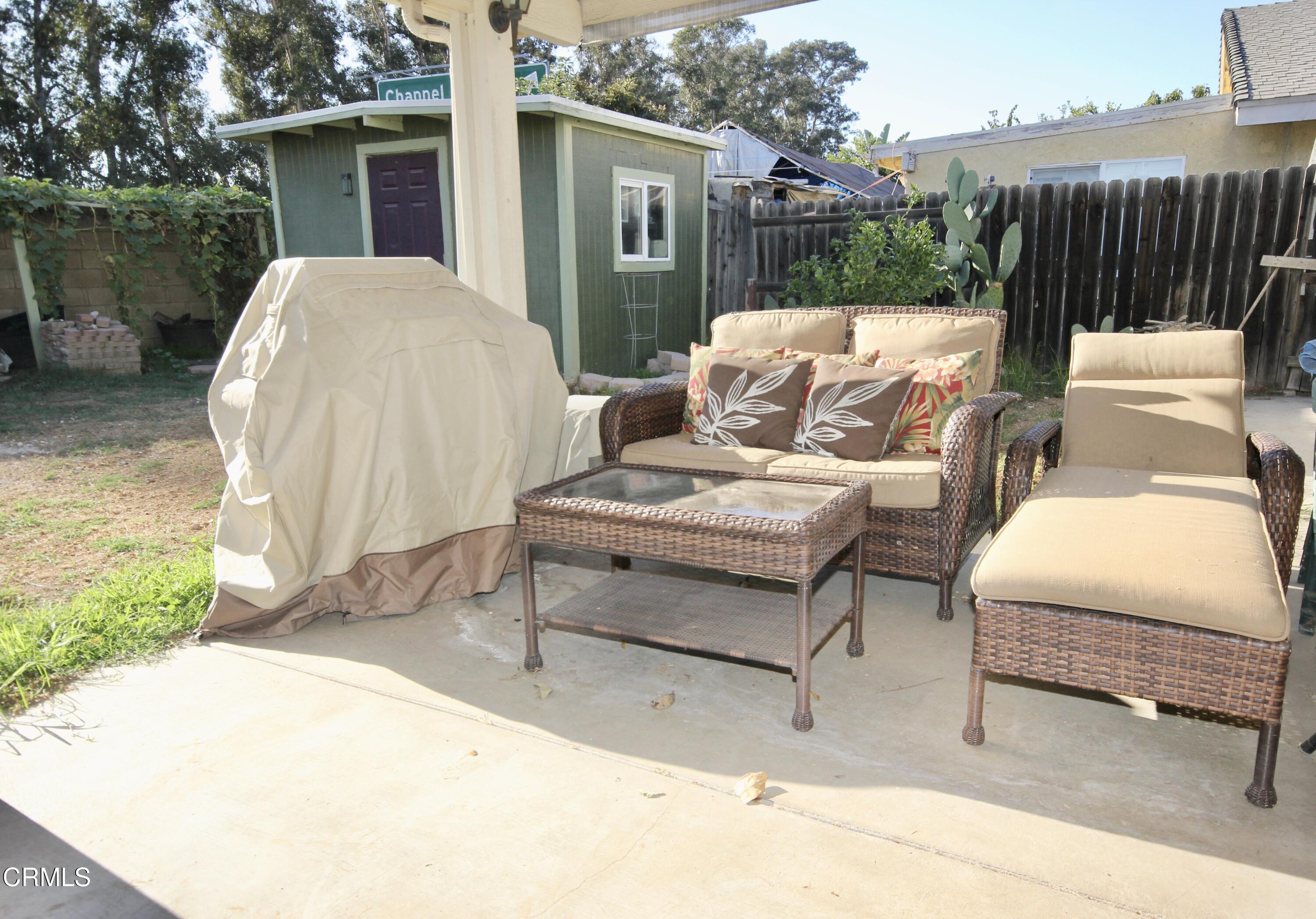1966 Sutter Place Oxnard, CA 93033 - Photo 18 of 19 a view of a patio with a table and chairs next to a yard