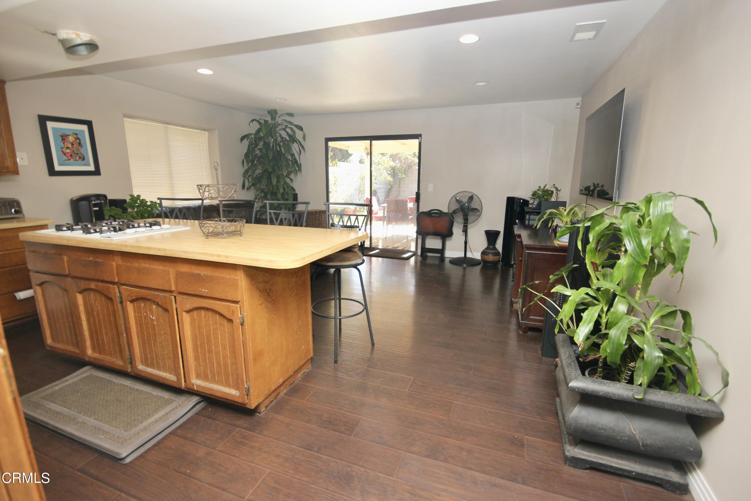1966 Sutter Place Oxnard, CA 93033 - Photo 7 of 19 a hallway with a dining table a chandelier and a window