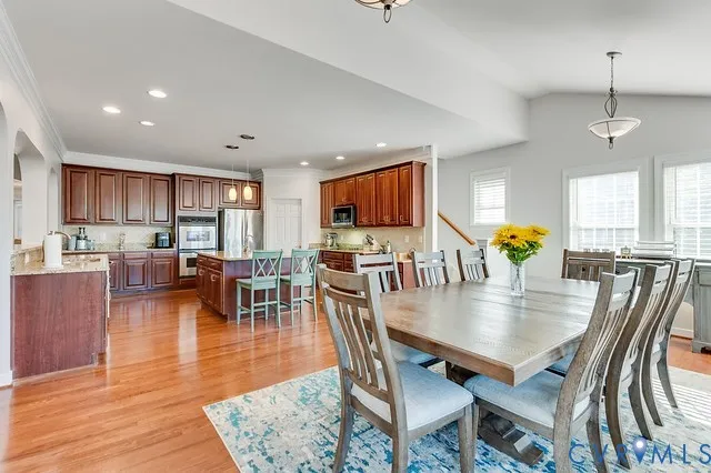 an open kitchen with dining table and wooden floors
