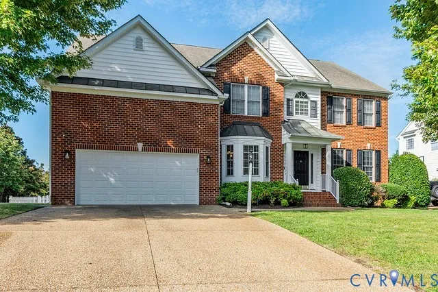 a front view of a house with a garden and plants