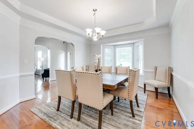 a view of a dining room with furniture a chandelier and wooden floor