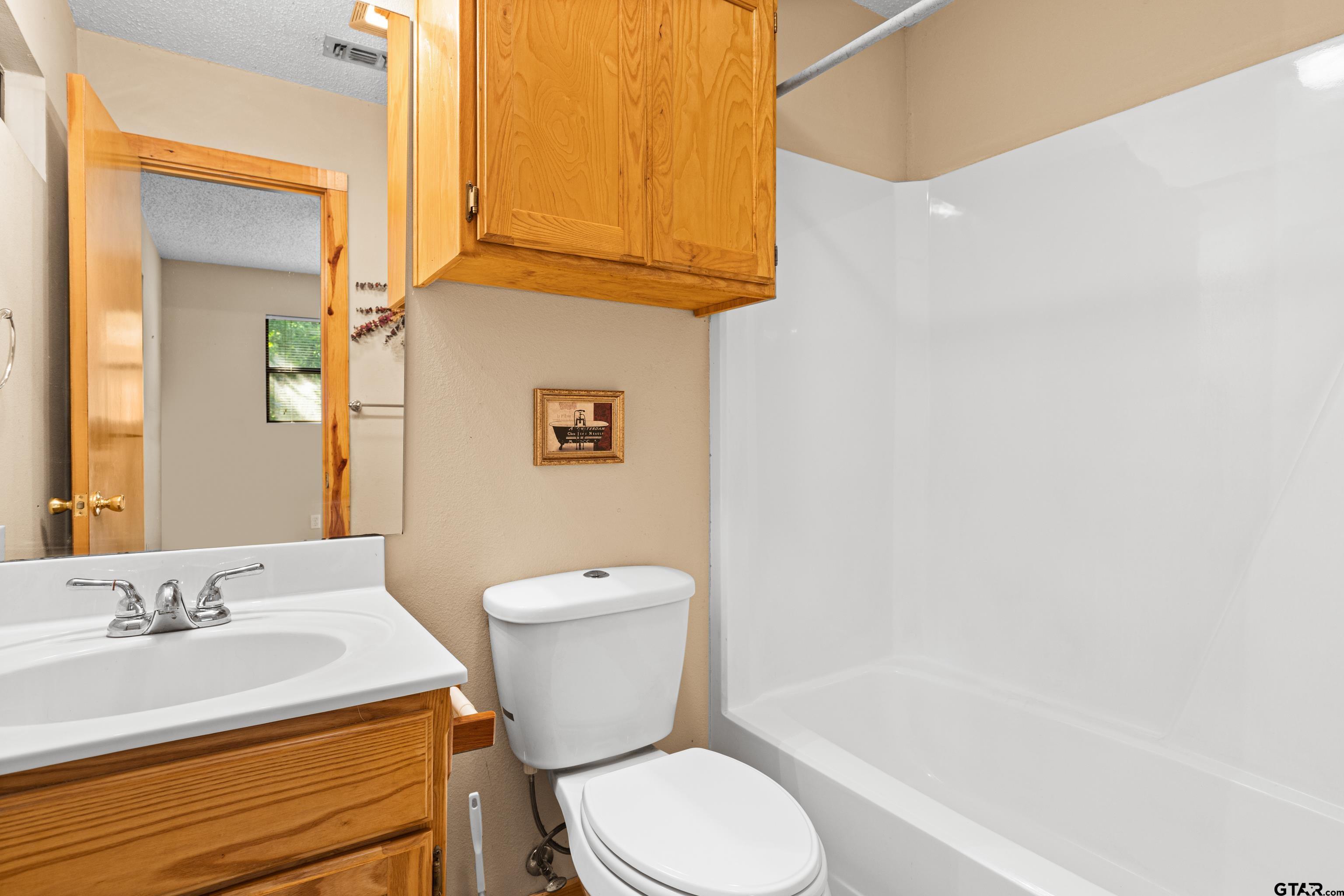 149 Primrose Path Holly Lake Ranch, TX 75765 - Photo 15 of 36 a bathroom with a sink a toilet and a bathtub