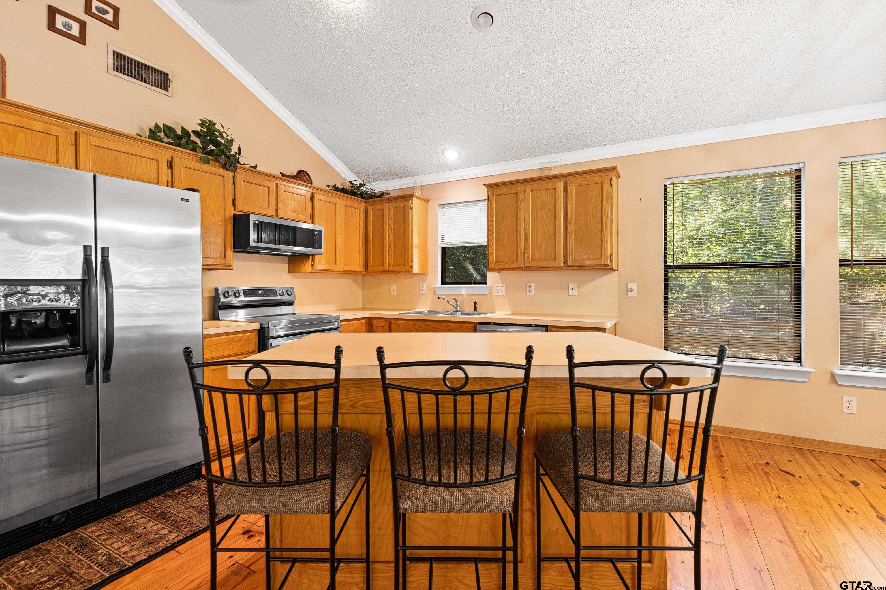 149 Primrose Path Holly Lake Ranch, TX 75765 - Photo 23 of 36 a kitchen with stainless steel appliances granite countertop a stove a sink island and a refrigerator