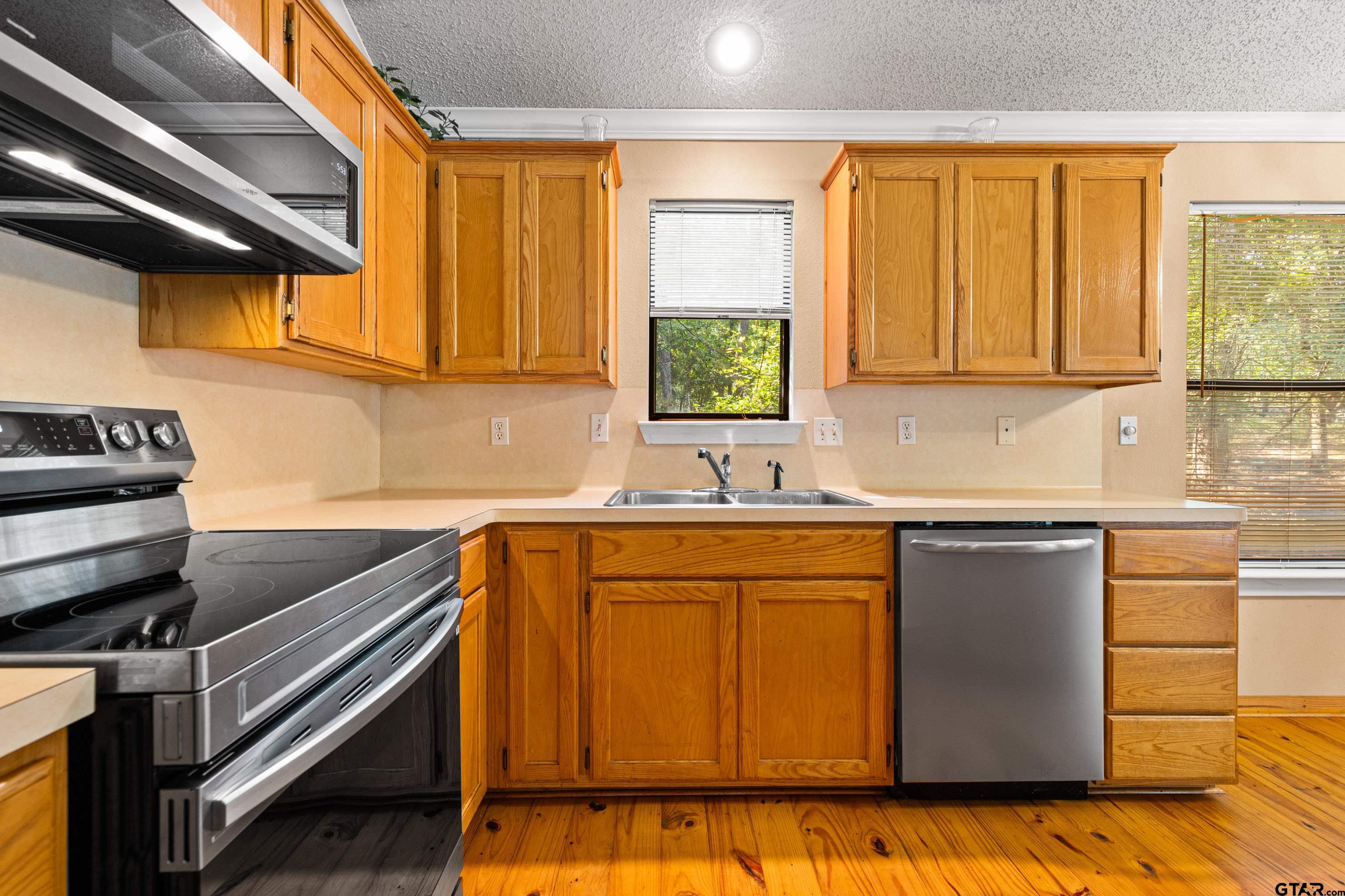 149 Primrose Path Holly Lake Ranch, TX 75765 - Photo 27 of 36 a kitchen with stainless steel appliances granite countertop a sink and a stove