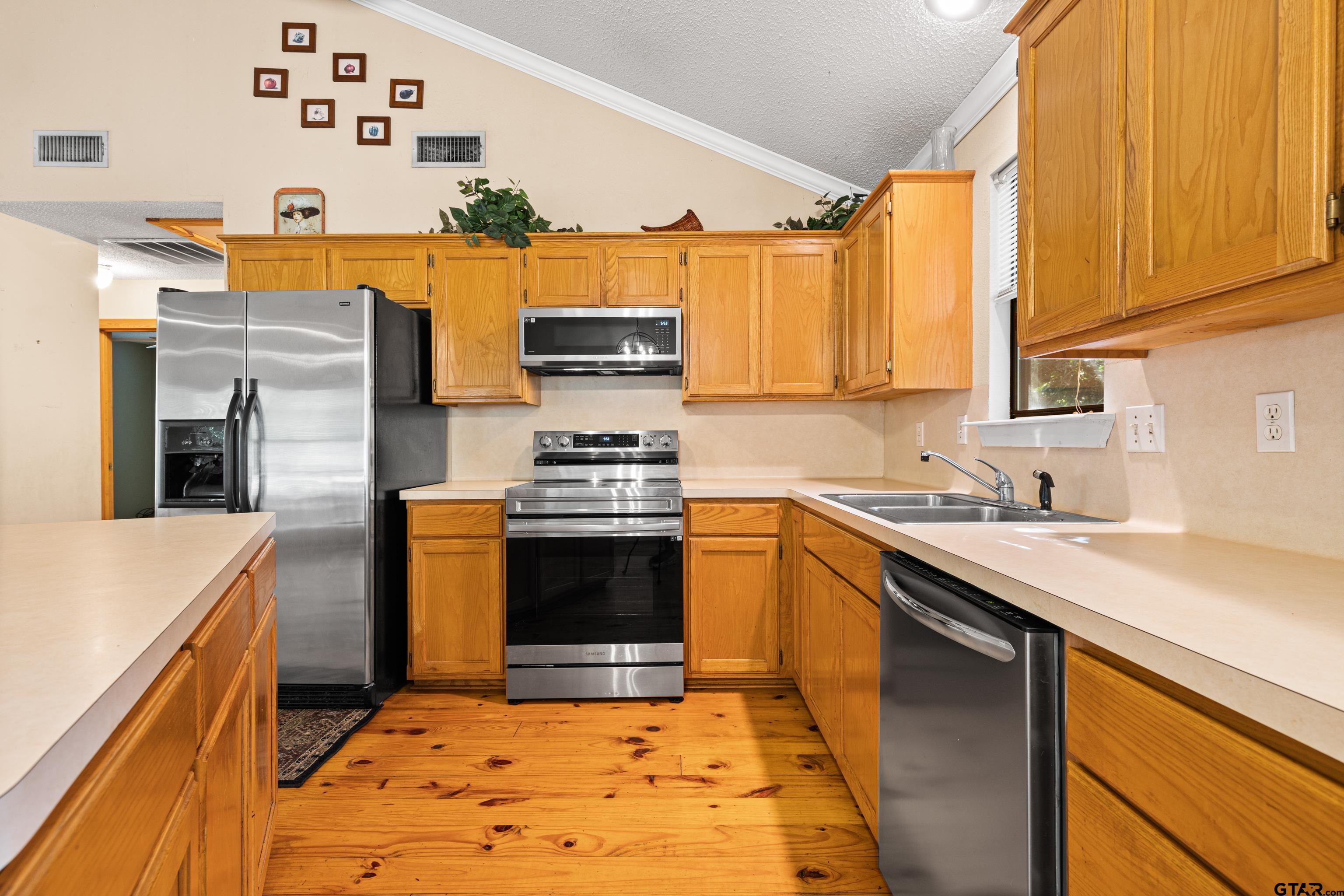 149 Primrose Path Holly Lake Ranch, TX 75765 - Photo 28 of 36 a kitchen with stainless steel appliances granite countertop a stove refrigerator and a sink