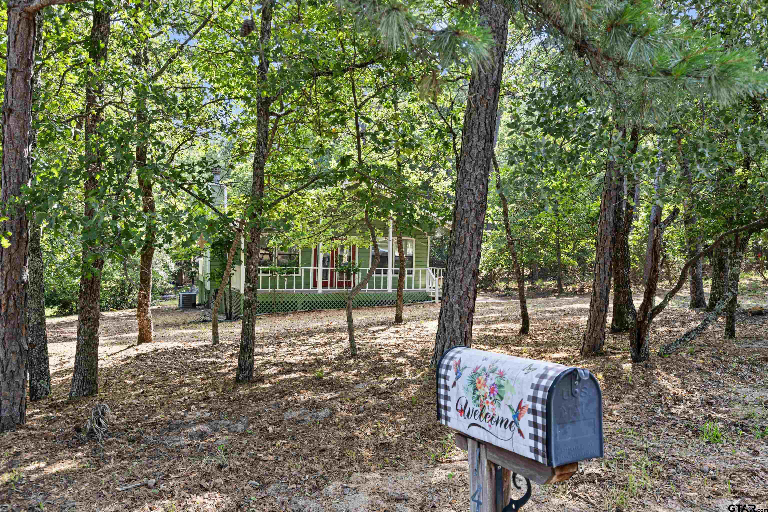 149 Primrose Path Holly Lake Ranch, TX 75765 - Photo 6 of 36 a backyard of a house with lots of green space and glass windows