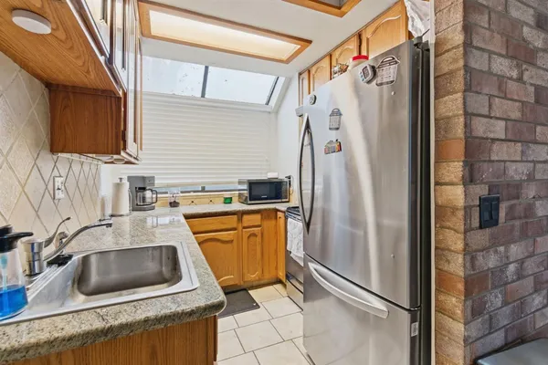 a kitchen with stainless steel appliances granite countertop a refrigerator a sink a stove and washer