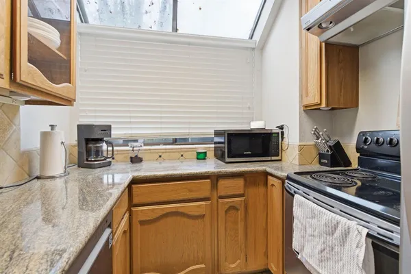 a kitchen with stainless steel appliances granite countertop a stove a sink and a microwave
