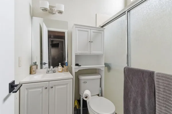 a bathroom with a sink vanity mirror and toilet