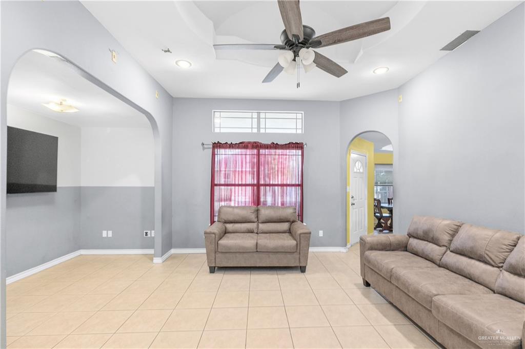 240 East Dicker Road Pharr, TX 78577 - Photo 17 of 23 Spacious living area featuring tile flooring, a tray ceiling with a ceiling fan, recessed lighting, and arched doorways
