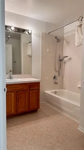 a bathroom with a granite countertop sink a mirror a bathtub and a shower