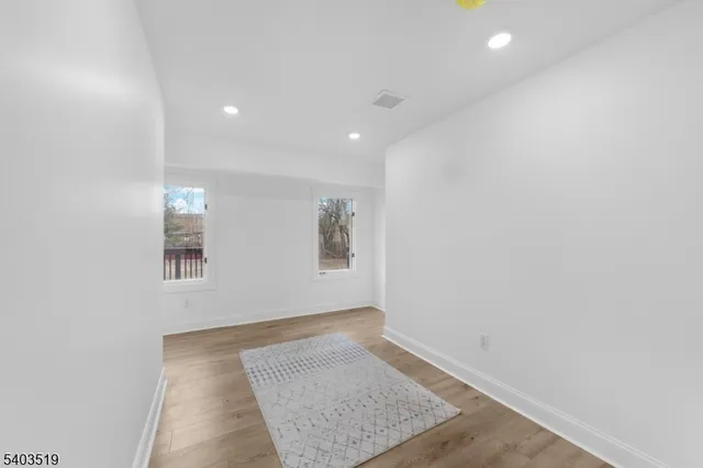 a view of an empty room with wooden floor