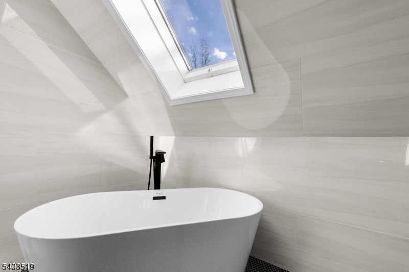 15 West Main Street Evesham, NJ 08053 - Photo 34 of 38 a bathroom with a white bath tub a sink and mirror