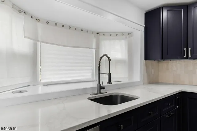 a kitchen with stainless steel appliances granite countertop a sink a stove and wooden floor