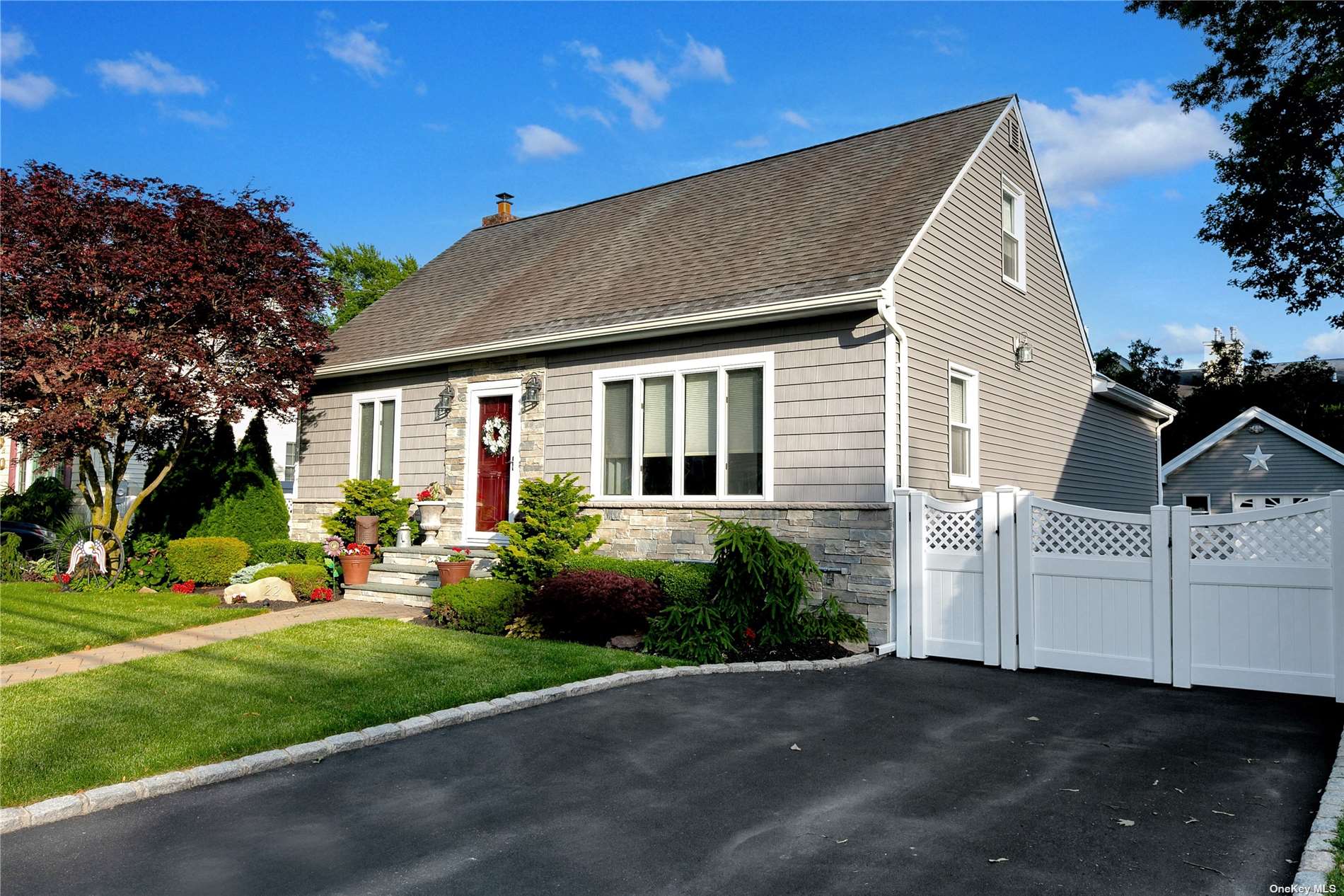 a front view of a house with a garden and plants