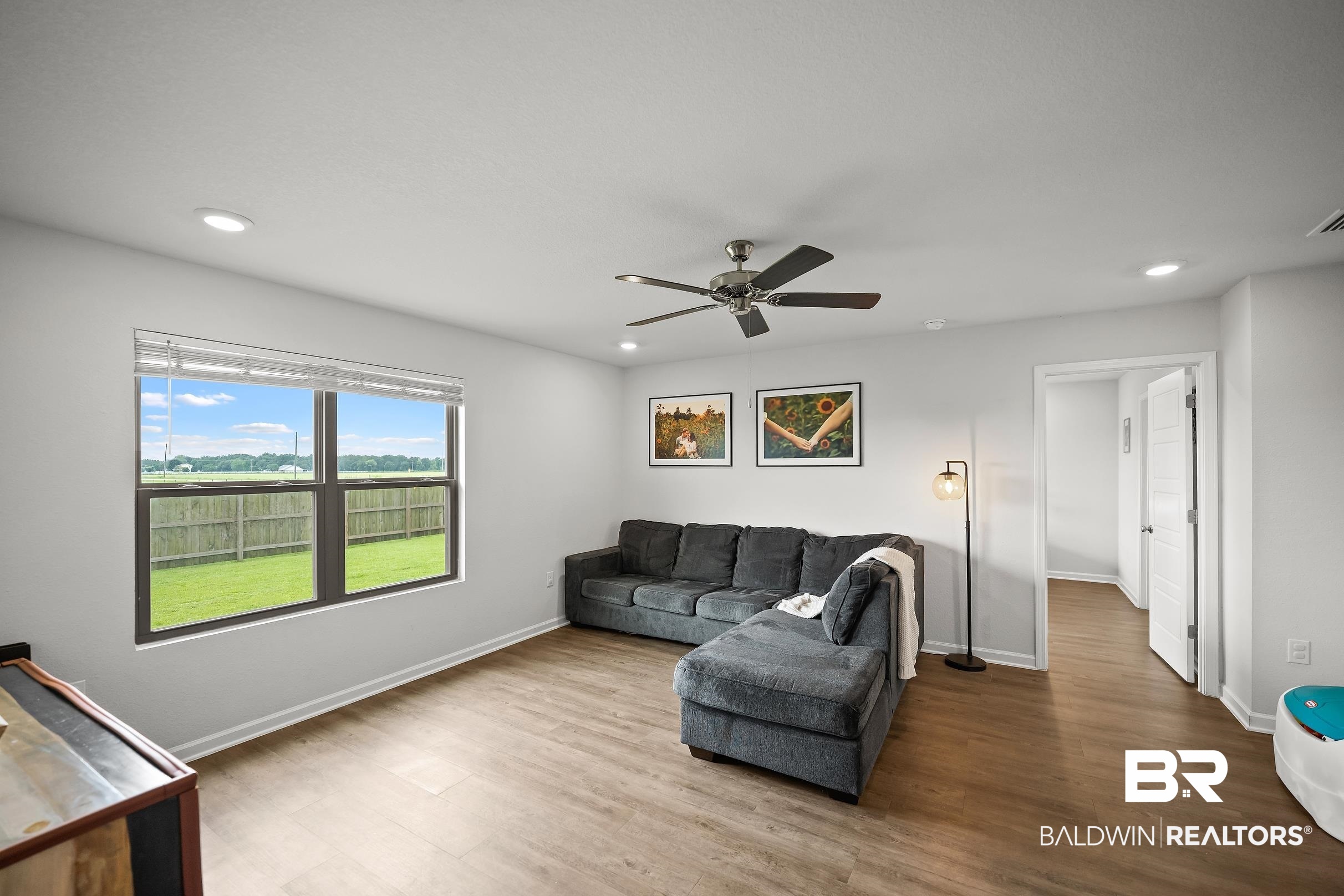 32030 Terranova Loop Lillian, AL 36549 - Photo 4 of 30 Spacious room featuring wood-finish flooring, a large window, and recessed lighting