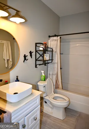 a white toilet sitting next to a bathroom sink and a shower