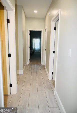 a view of a hallway with wooden floor and closet area