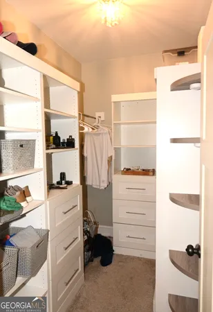 a view of walk in closet with clothes and shoes